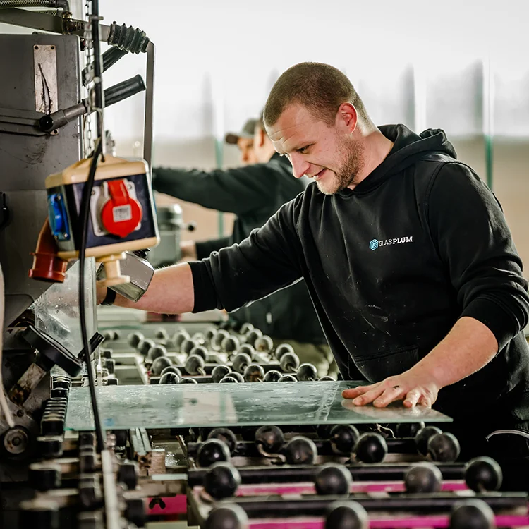 Glücklicher Mitarbeiter bei der professionellen Glasverarbeitung bei Glas Plum , dem Glaser Region Düren.